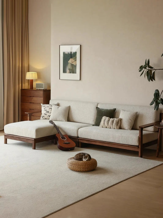 Wide lifestyle view of the Daren sectional with chaise in a warm living room with guitar, cat, and natural light