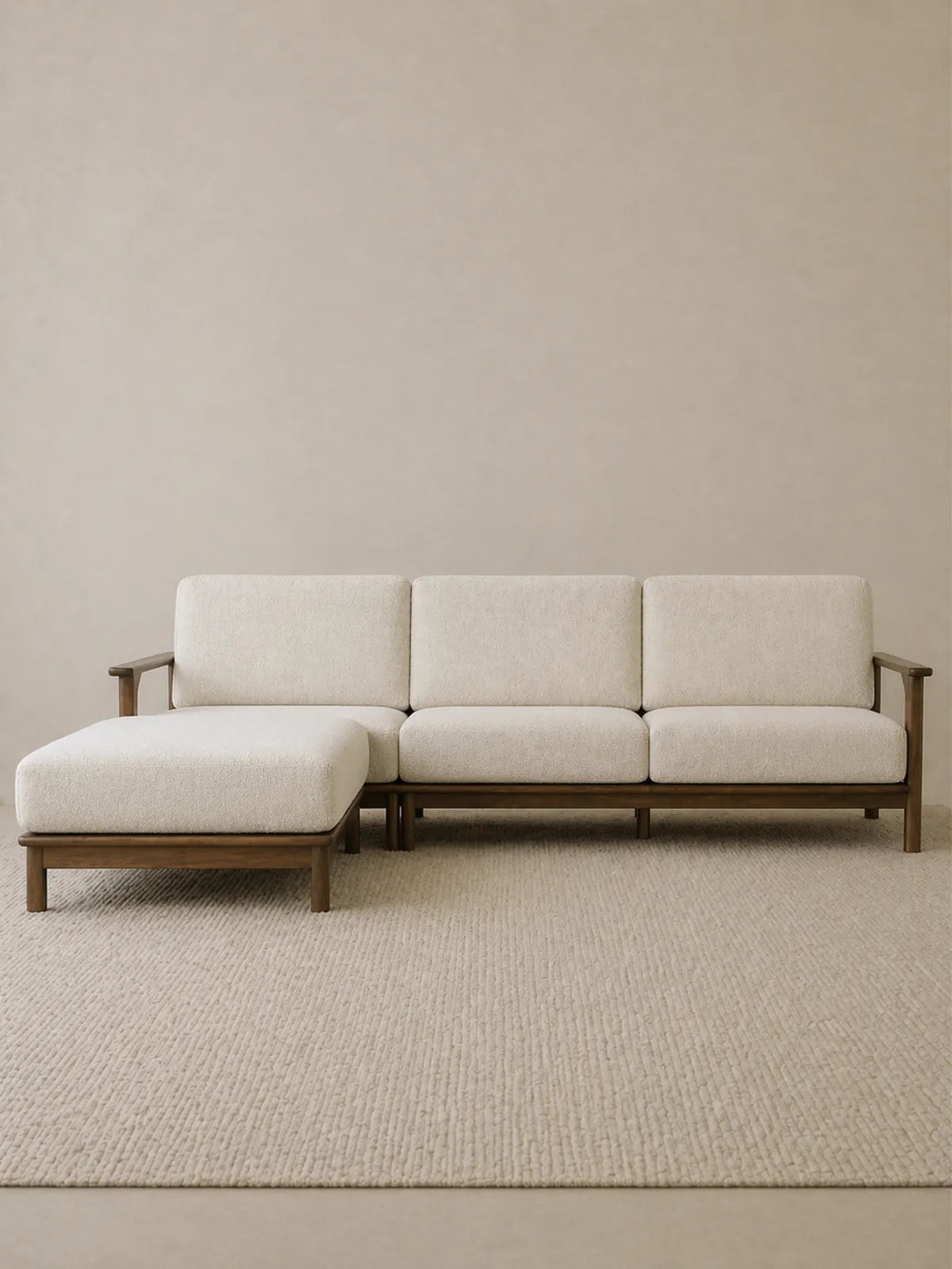 Daren sectional sofa in solid walnut with cream upholstery and left chaise lounge, front three-quarter view on neutral rug