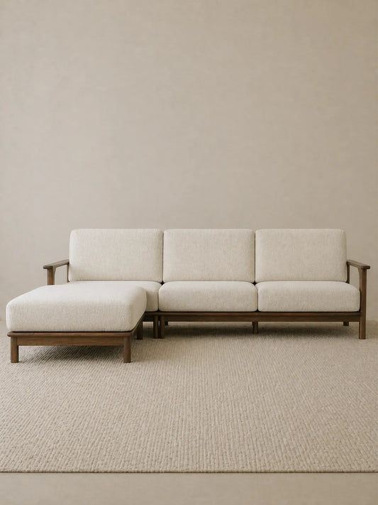 Daren sectional sofa in solid walnut with cream upholstery and left chaise lounge, front three-quarter view on neutral rug