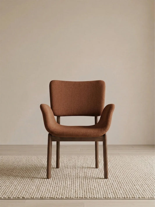 Front view of a brown upholstered dining armchair with sculpted arms and walnut frame (Burnt Sienna)