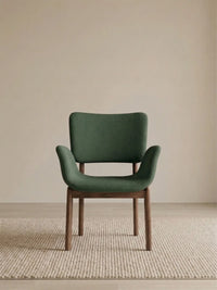 Front view of a green upholstered dining armchair with solid American black walnut legs (Conifer)