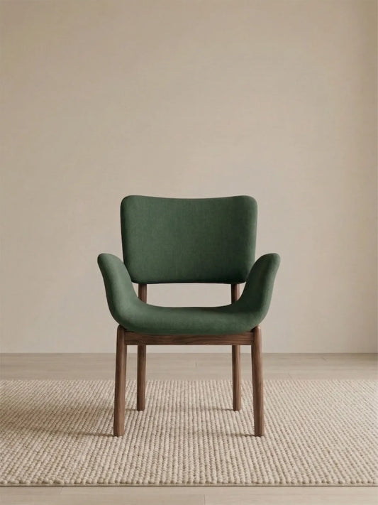 Front view of a green upholstered dining armchair with solid American black walnut legs (Conifer)