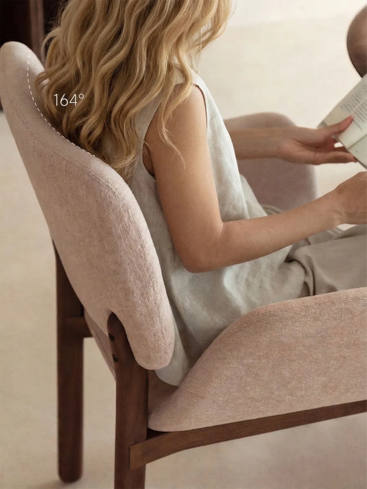 Side detail of the upholstered walnut dining armchair showing the gently reclined back angle