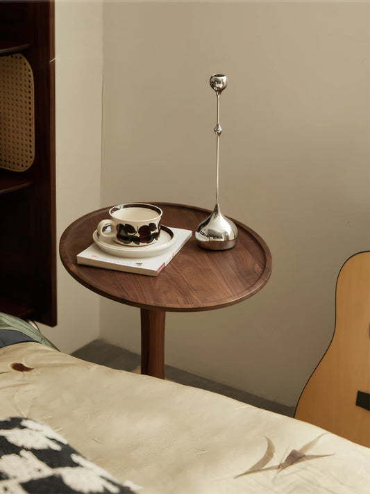 The Orbit end table solid wood piece styled elegantly with a silver candle holder, demonstrating its fit for organic modern interiors.