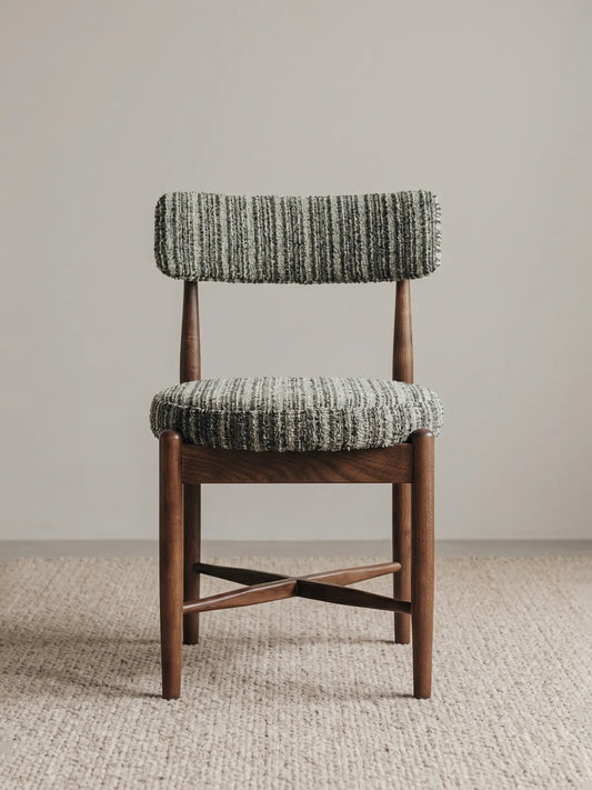 Eron upholstered dining chair in solid walnut, front view showing textured bouclé seat and curved padded backrest