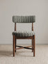 Eron upholstered dining chair in solid walnut, front view showing textured bouclé seat and curved padded backrest