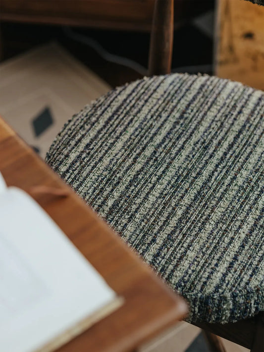 Overhead angle of the Eron dining chair showing rounded upholstered seat and walnut frame beneath