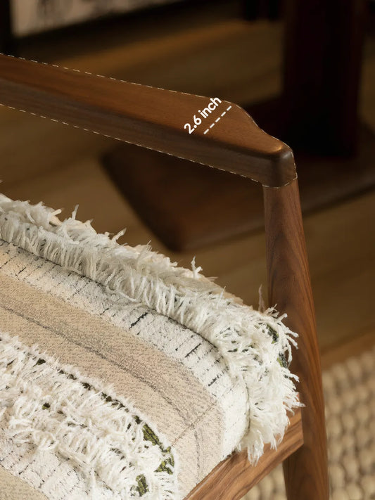 Close-up of Eron lounge chair sculpted walnut arm showing 2.6 inch profile and woven cushion texture
