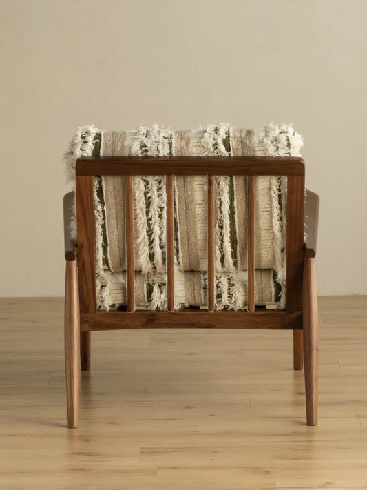 Eron lounge chair front view with textured striped cushions and solid walnut frame on hardwood floor