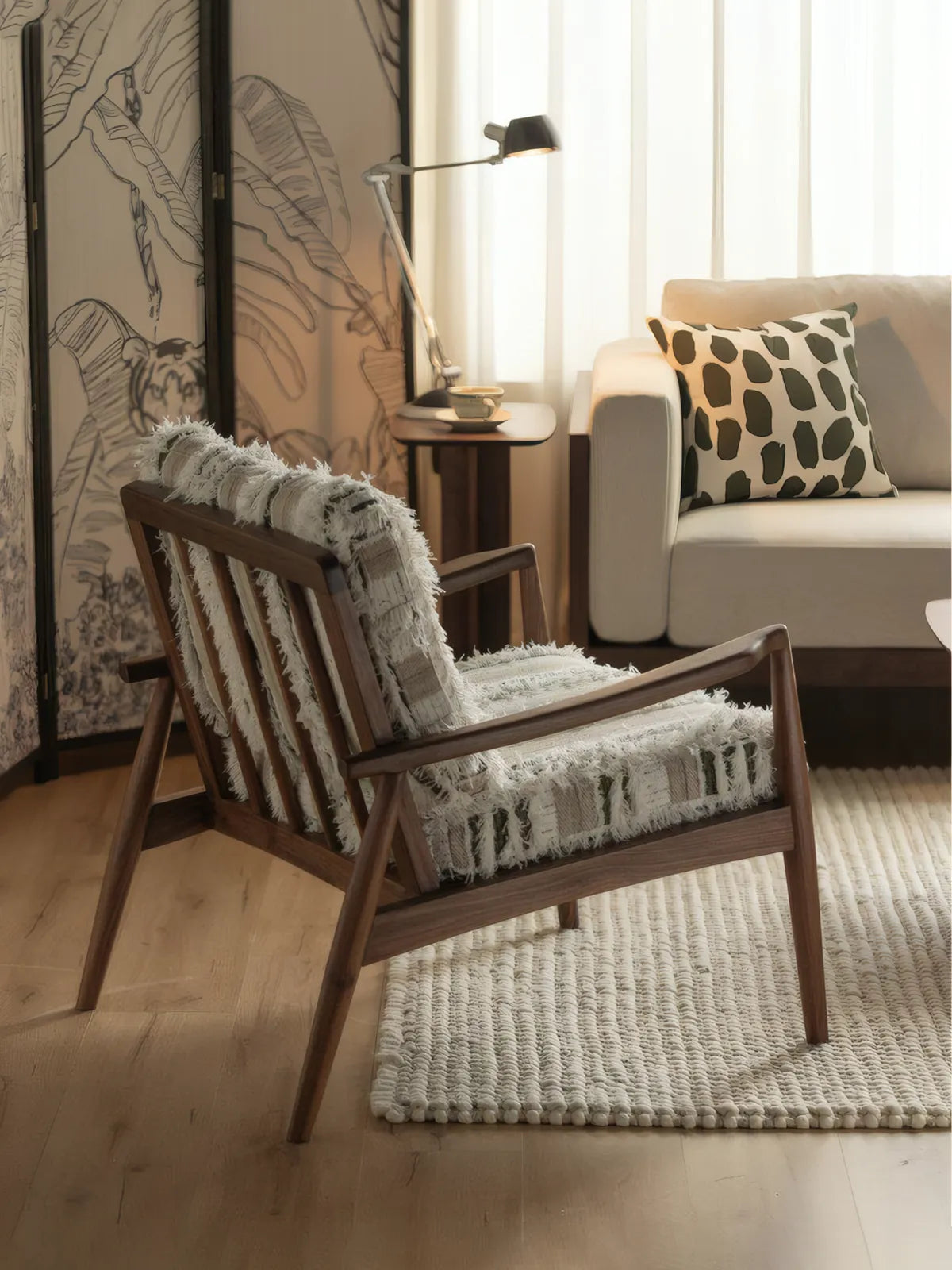 Eron lounge chair rear three-quarter view showing walnut spindle back and tapered legs in living room