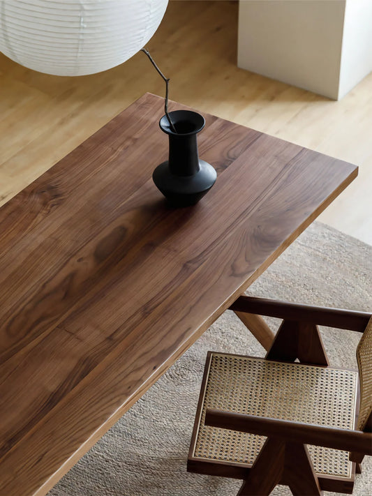 Overhead detail of the Estate dining table showing rich American black walnut grain and a softly beveled rectangular top.