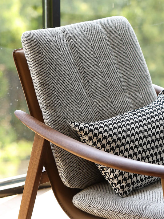 Close-up of the gray mid century modern chair featuring premium herringbone upholstery and a throw pillow.