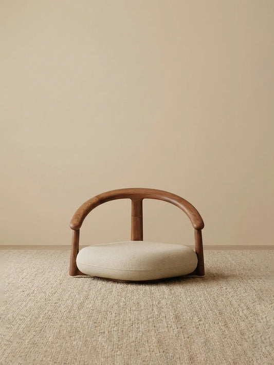 A clean studio front view of The Haven Wide-Seat Floor Chair, showcasing its thick, plush cushion and classic semi-circular walnut backrest.