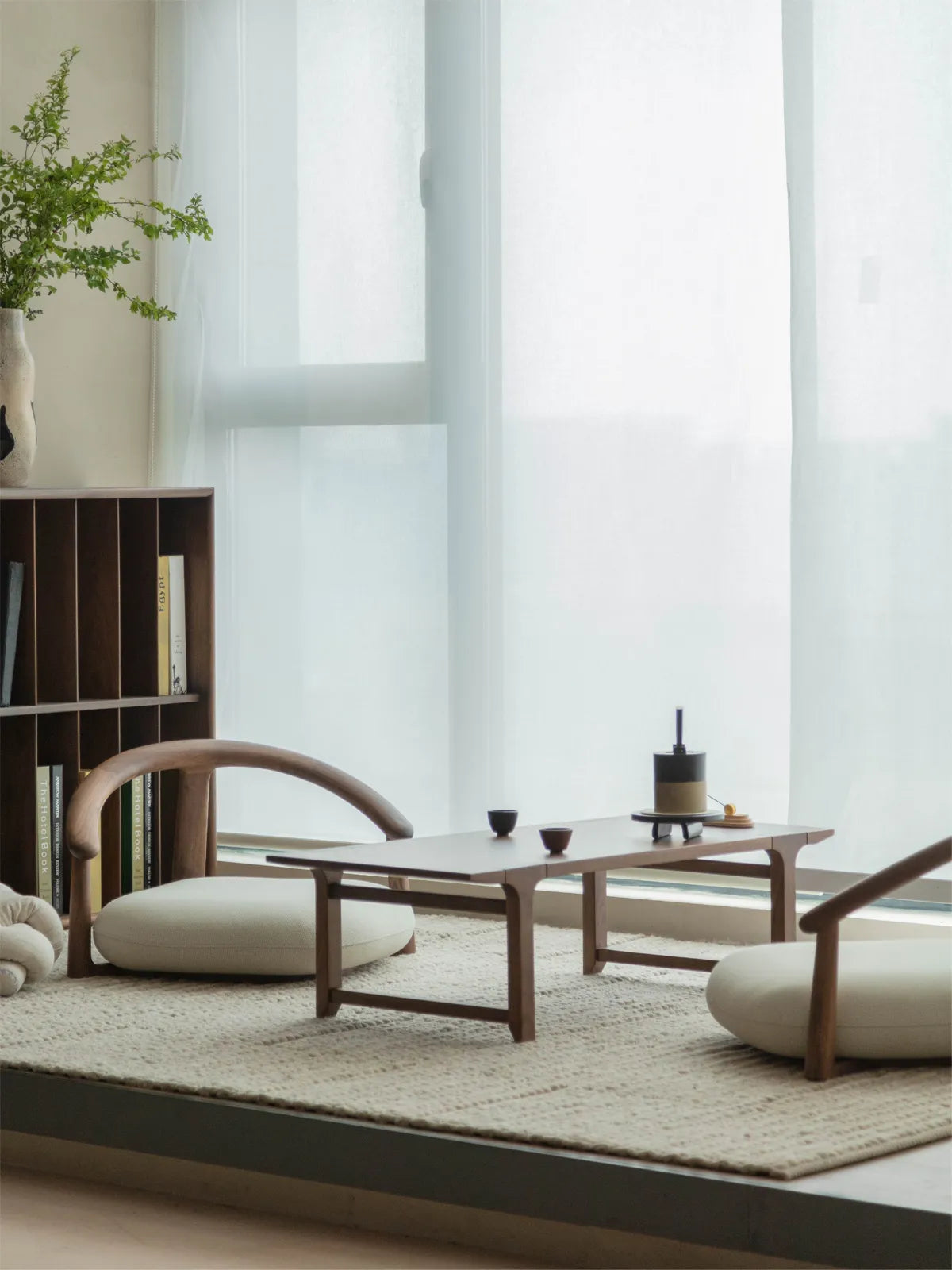 Two solid walnut Haven Floor Chairs arranged around a low coffee table on a textured rug, perfect for minimalist living room floor seating.