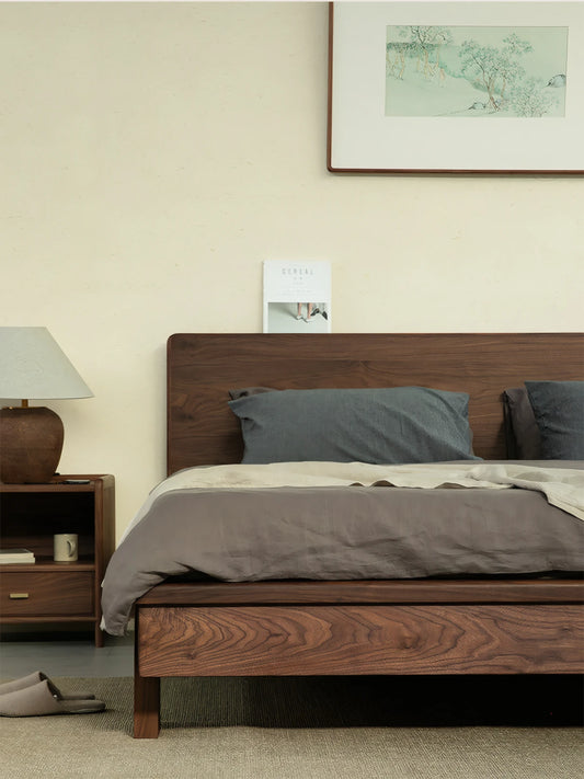 The Helios solid black walnut bed frame by Walnutry, paired with a matching wooden nightstand in a relaxing modern bedroom setting.
