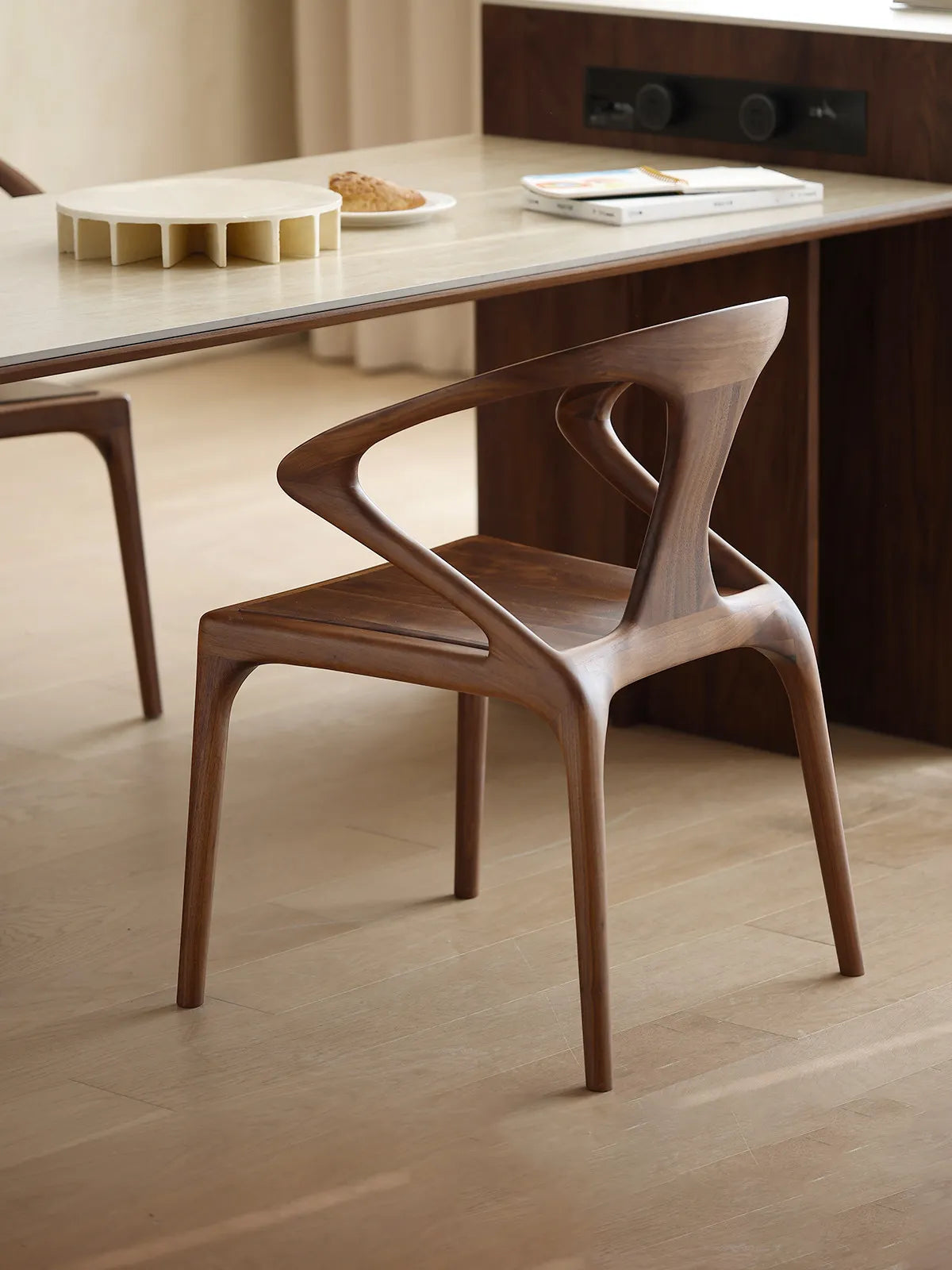 Rear angle of the Helios dining chair displaying the unique, floating backrest design and smooth joinery.