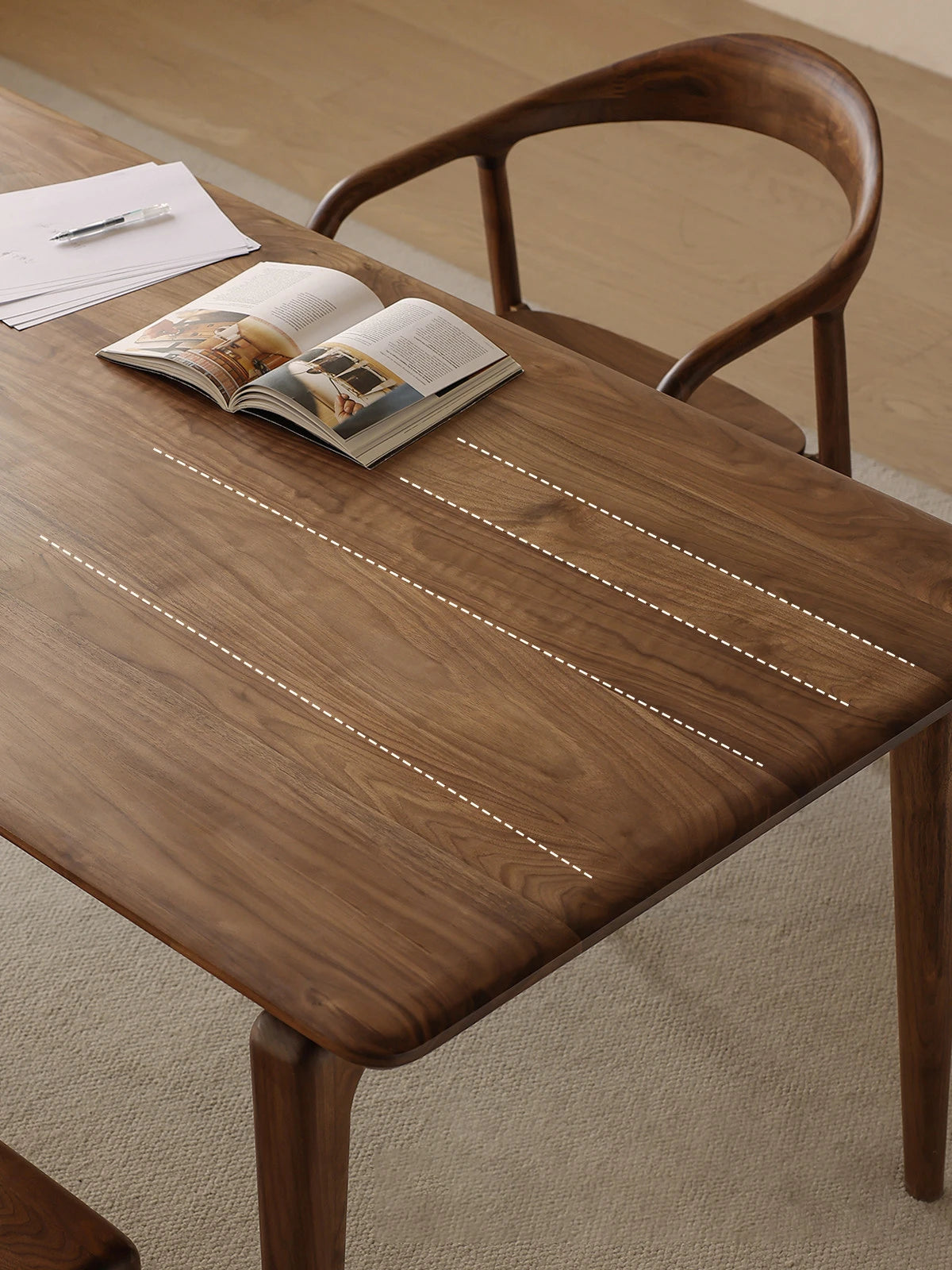 Close-up of the Helios walnut dining room table surface, highlighting the beautiful continuous wood grain of North American Black Walnut.
