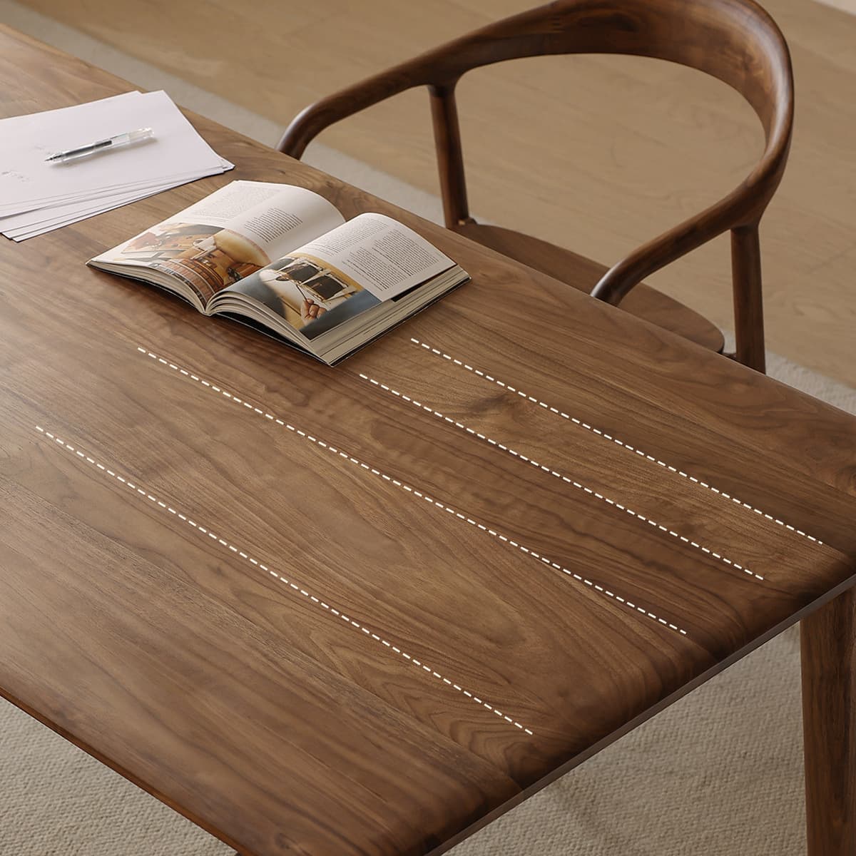 Detailed view of the Walnutry Helios dining table surface with overlay lines highlighting the wide stave layout and consistent grain pattern of the solid walnut.