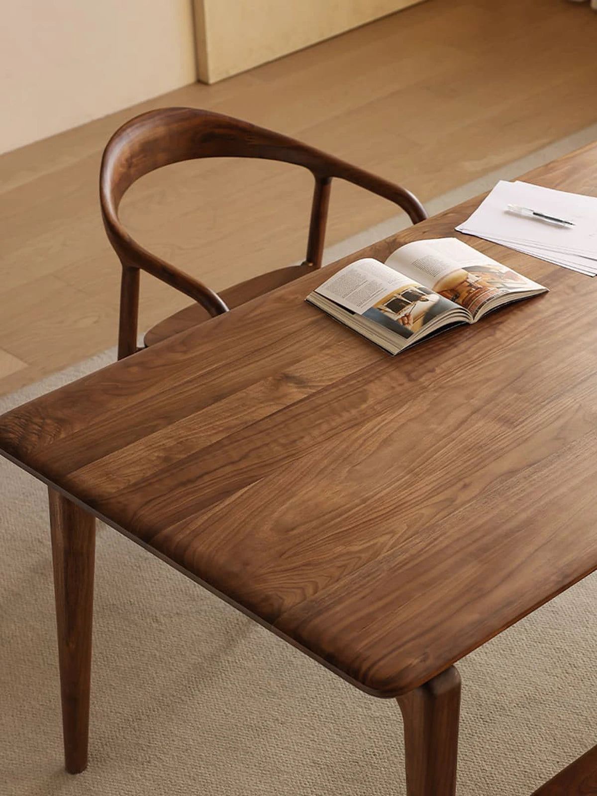 Angled lifestyle view of the mid century modern wood dining table showcasing its smooth rounded corners and safe, family-friendly design.
