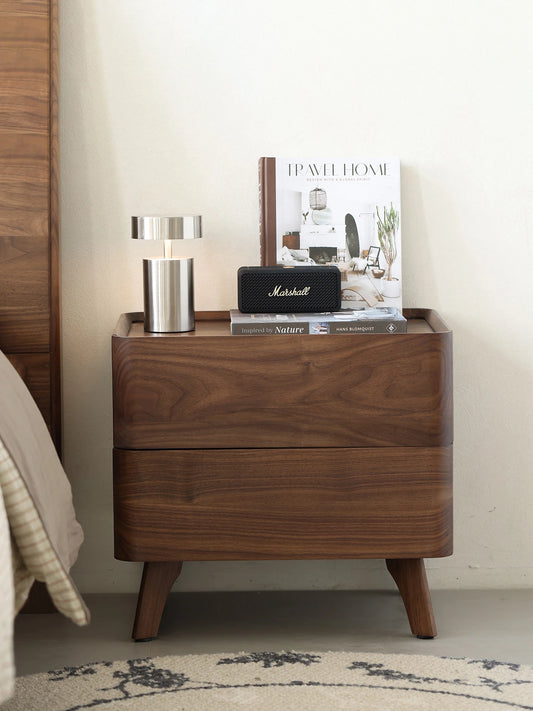 Front lifestyle view of The Helios mid-century modern nightstand, perfectly complementing a solid wood bed frame and creating a warm bedroom aesthetic.