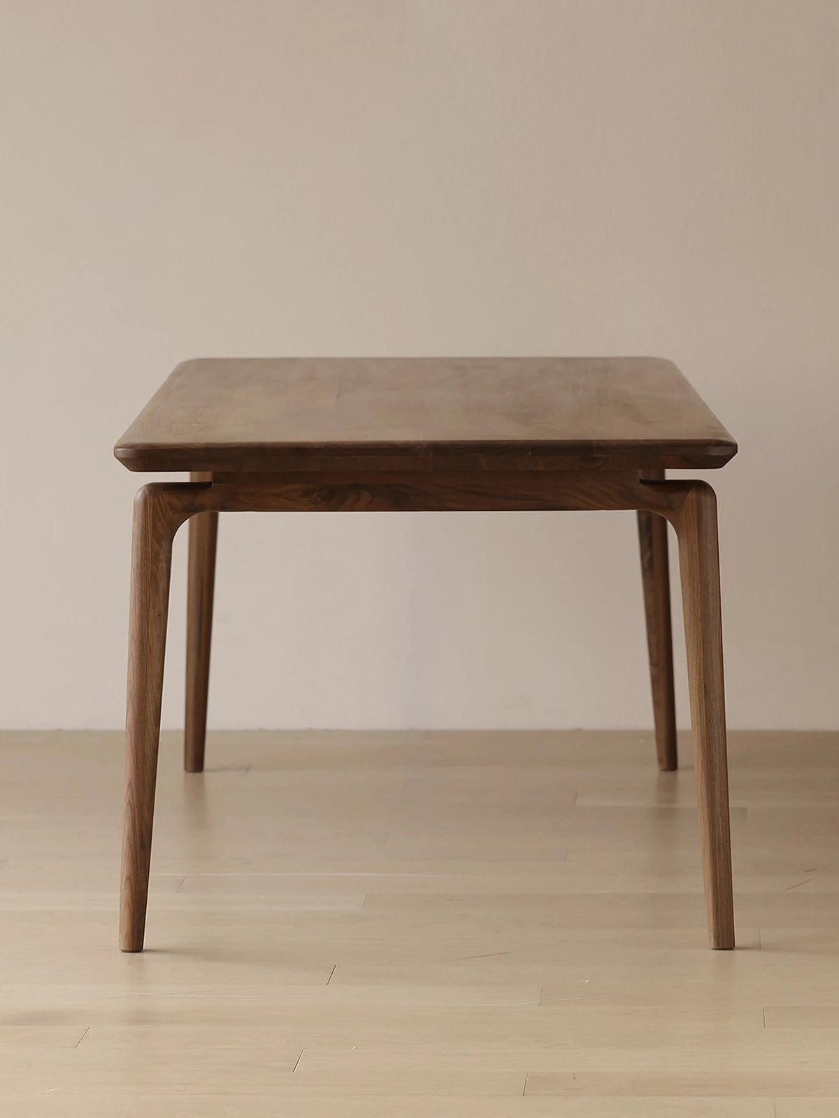 Clean front studio view of the rectangular mid century modern dining table by Walnutry, featuring smooth rounded edges and elegant tapered legs.