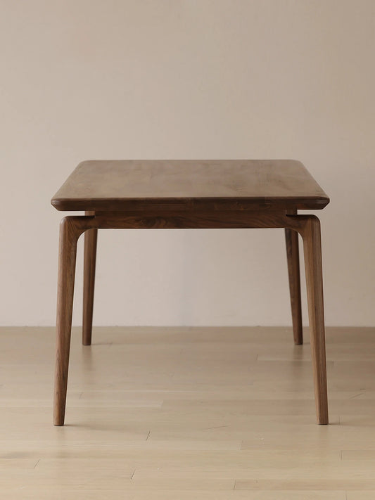 Clean front studio view of the rectangular mid century modern dining table by Walnutry, featuring smooth rounded edges and elegant tapered legs.
