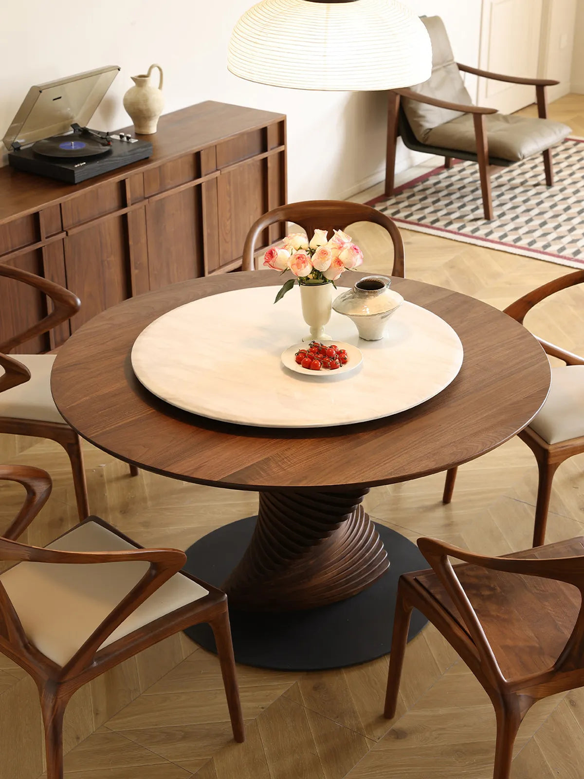 High-angle view of The Helios Round Dining Table showcasing the convenient integrated white marble Lazy Susan, surrounded by mid-century modern dining chairs.