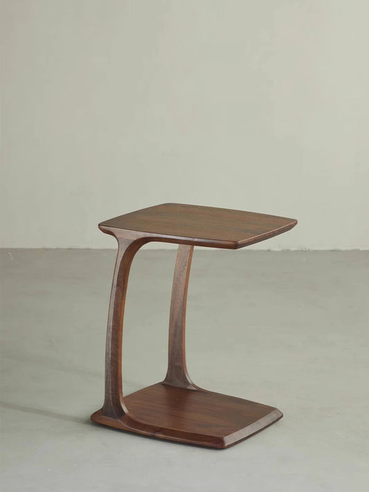 The Helios C-Table by Walnutry, crafted from solid North American Black Walnut with a sleek, curved mid-century modern design.