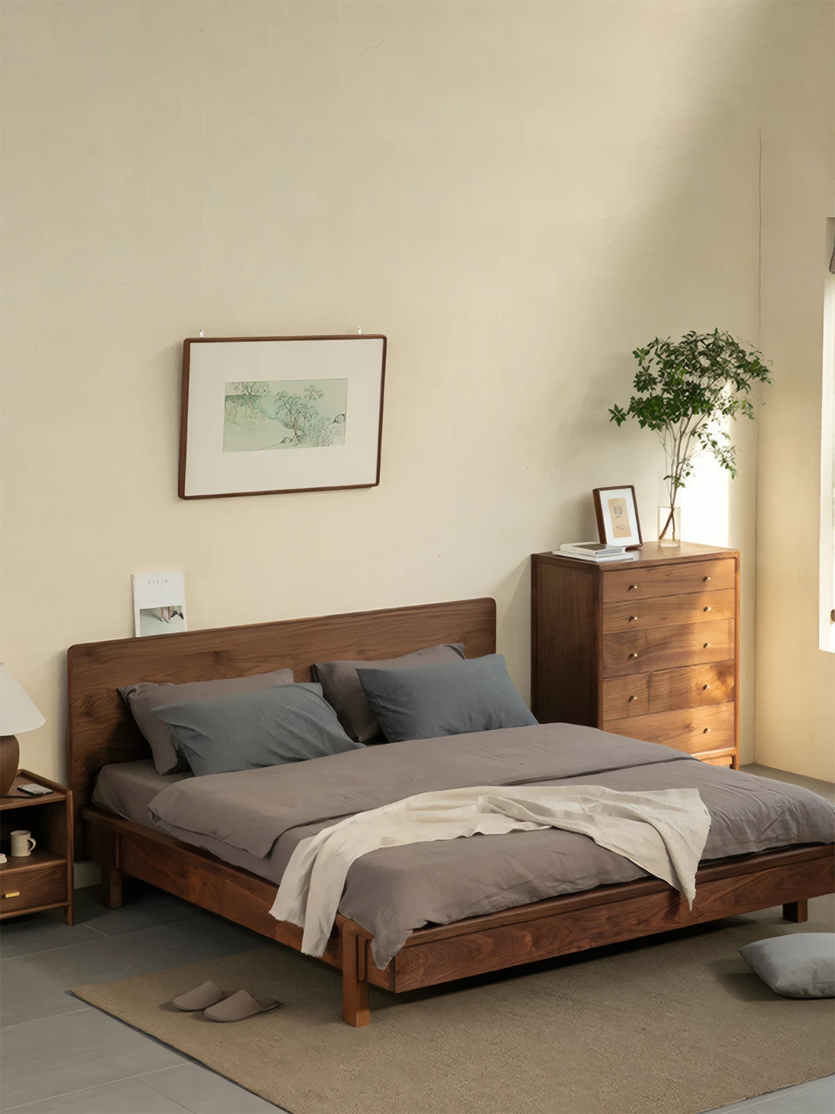 The Helios solid black walnut bed frame styled in a bright, sunlit bedroom, showcasing its minimalist aesthetic and premium wood finish.
