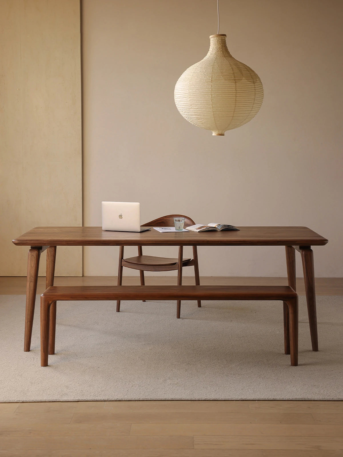 The versatile Helios table functioning beautifully as a spacious solid wood walnut desk with a laptop, perfect for a home office setup.