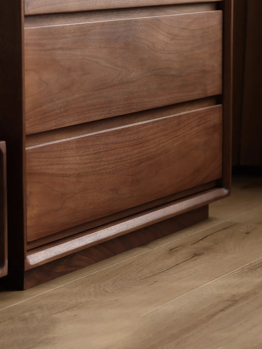 Close-up of the solid North American Black Walnut base and lower drawers of The Heritage 5-Drawer Tallboy, showcasing natural wood grain.