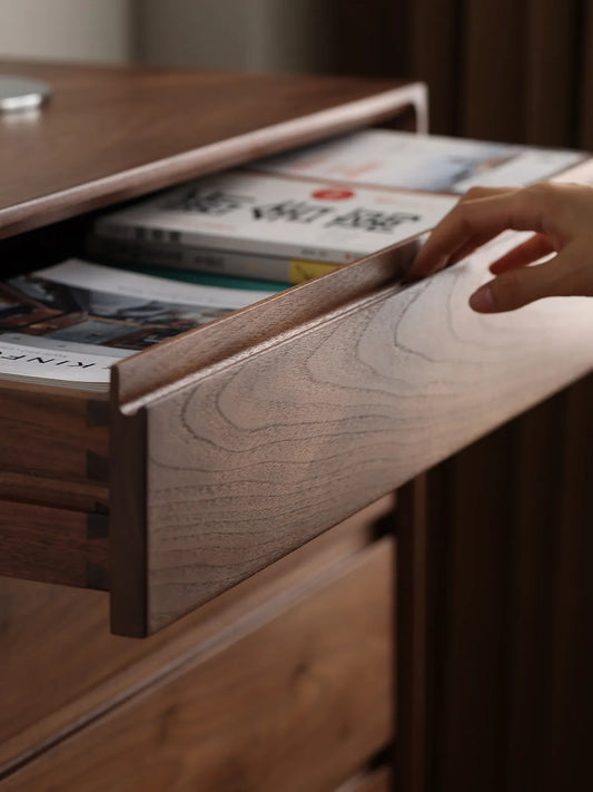 Hand opening the top drawer of The Heritage 5-Drawer Tallboy, highlighting the ergonomic integrated grooved handle design.