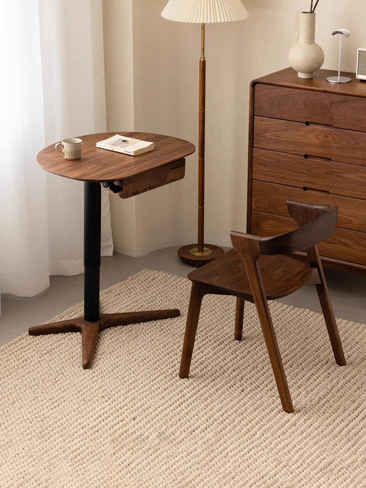 The Heritage side table paired with a matching solid walnut chair in a warm living room, serving perfectly as a small reading desk.