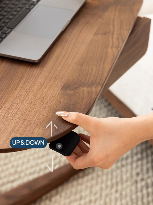 Close-up of a hand operating the easy up-and-down pneumatic lever beneath the solid black walnut top of The Heritage Adjustable Side Table.