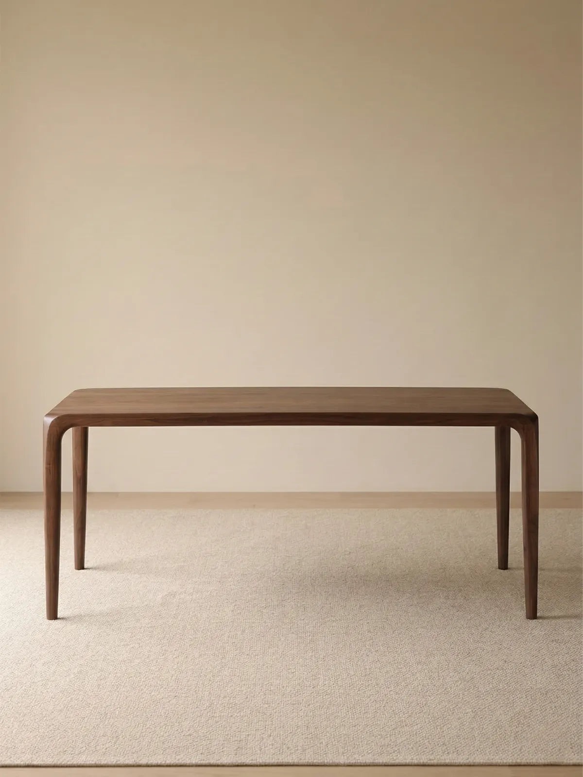 Front studio view of the Heritage black walnut dining table, featuring an organic modern silhouette and tapered legs.