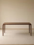 Front studio view of the Heritage black walnut dining table, featuring an organic modern silhouette and tapered legs.