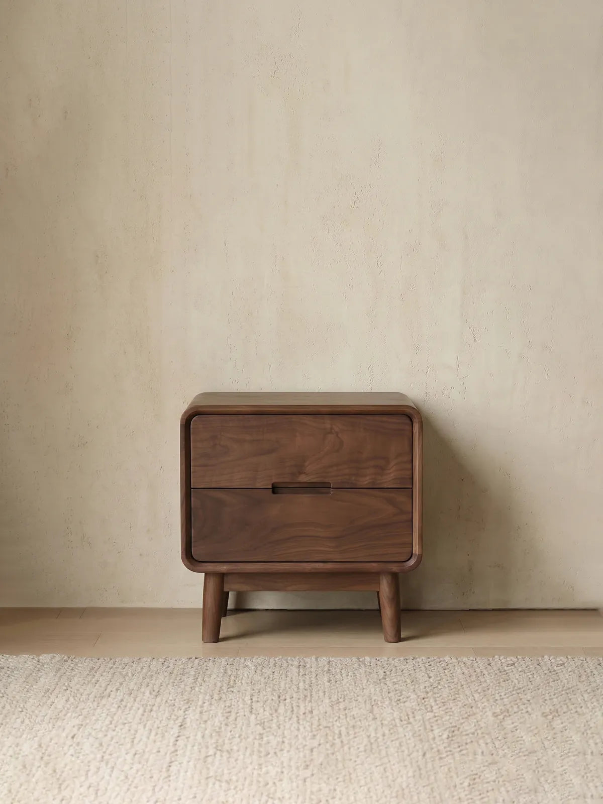 Clean front view of the Heritage black walnut nightstand, showcasing its integrated drawer pulls and elegant tapered legs.