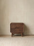 Clean front view of the Heritage black walnut nightstand, showcasing its integrated drawer pulls and elegant tapered legs.