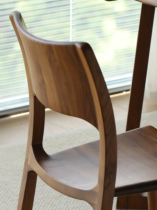 Detailed macro shot of the smoothly crafted, curved solid North American Black Walnut backrest on The Heritage Dining Chair.