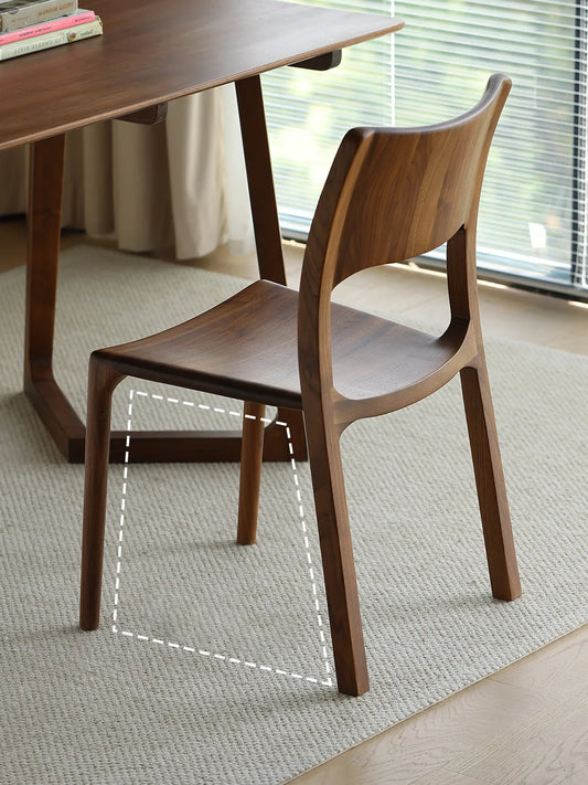 Angled back view of The Heritage Dining Chair showing the sturdy, splayed solid walnut legs designed for maximum stability.