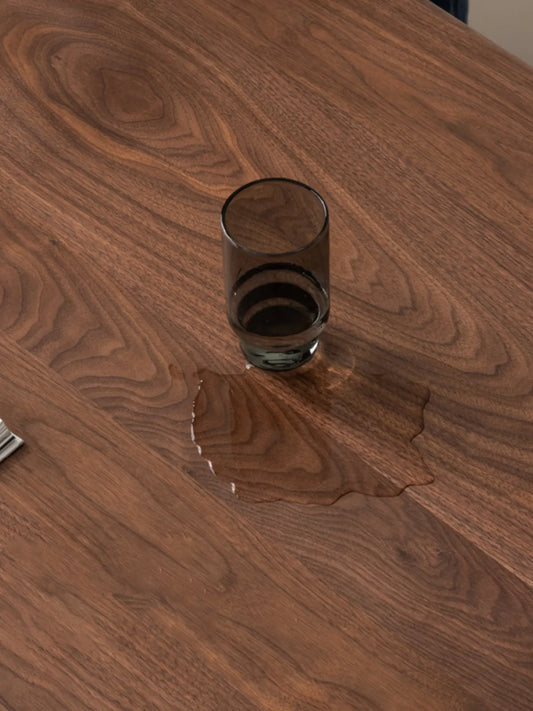 Close-up of water droplets on the table surface, demonstrating the durable water-resistant wood wax oil finish.