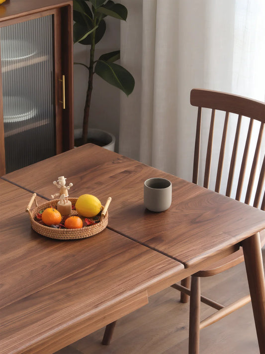 Close view of the walnut extendable dining table top showing the center extension seam and refined wood grain
