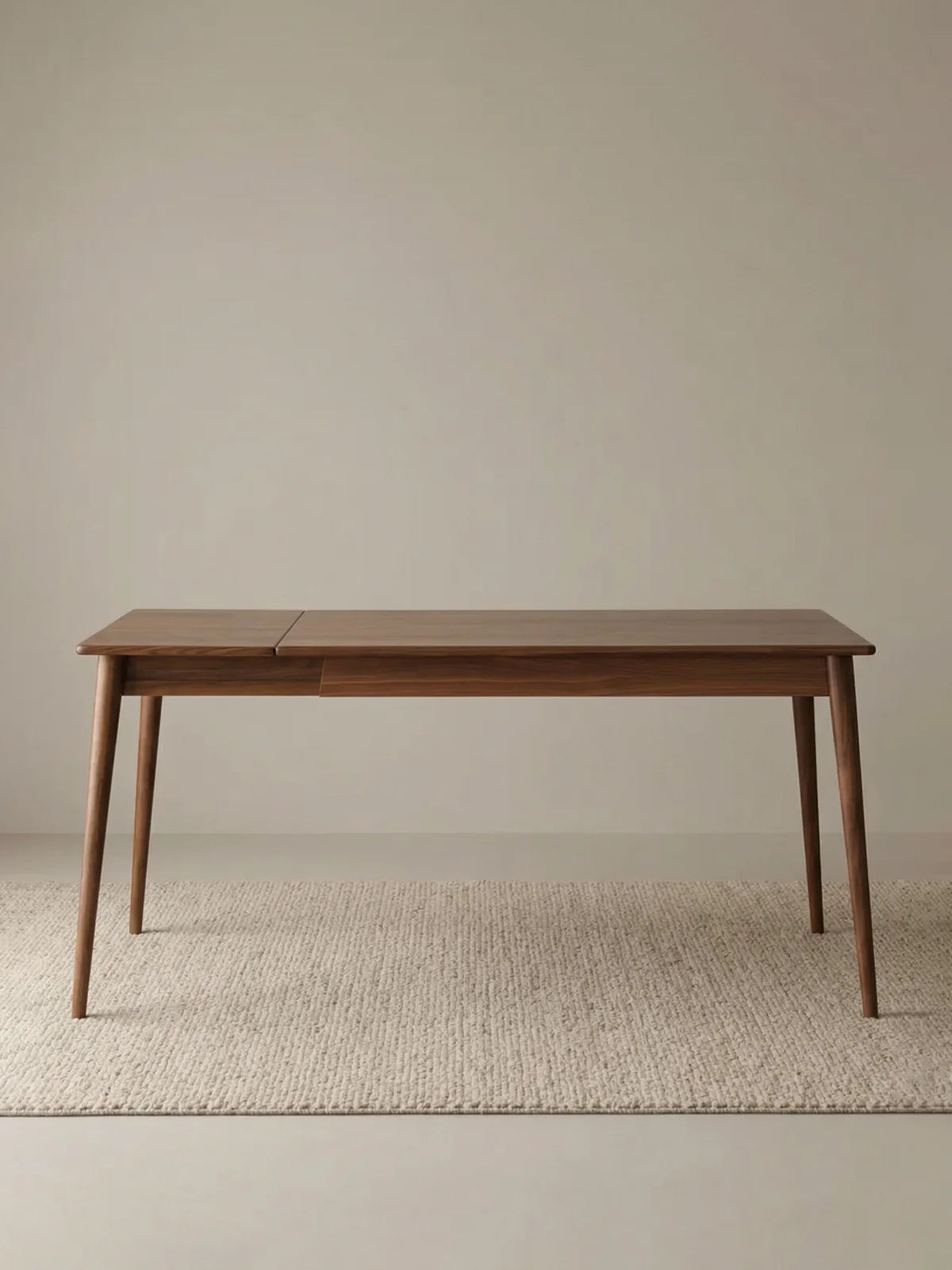 Studio view of the rectangular extendable dining table in solid American walnut with clean minimalist styling