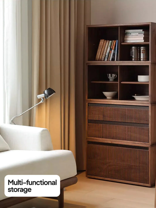 The Heritage modular cabinet stacked vertically as a tall mid century modern bookcase with doors next to a white sofa, showcasing multi-functional storage.