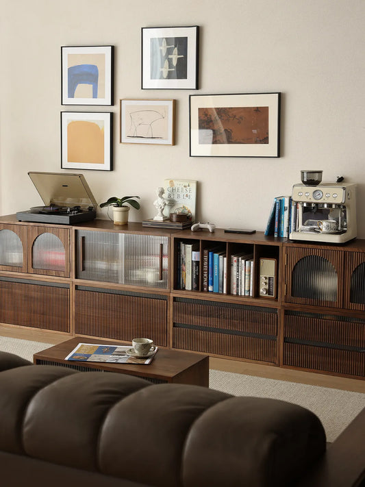 The Heritage modular cabinet arranged as a long mid century modern sideboard, displaying a turntable and curated books on its Black Walnut surface.