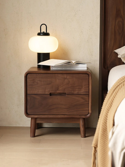 A minimalist bedroom setting featuring our modern walnut nightstand next to a clean, white bed setup.