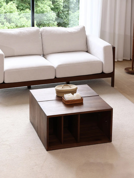 Two base units of the Heritage modular cabinet positioned back-to-back as a low solid walnut coffee table with open storage cubbies in a bright living space.