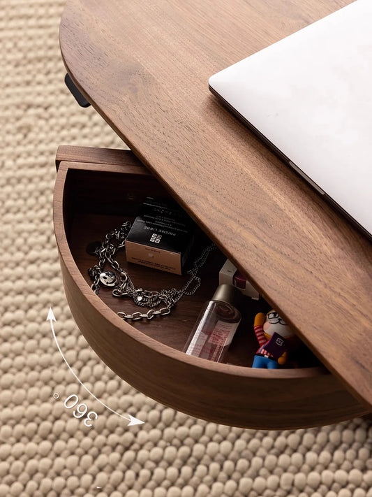 Top-down view of the 360-degree swiveling storage drawer under The Heritage table, open to reveal organized personal accessories.