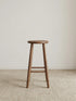 Walnutry Heritage Walnut Stool front view, solid wood counter height stool with round seat, tapered legs, and warm walnut grain for mid century modern kitchen seating