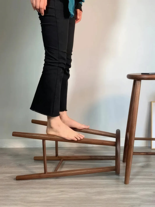 Walnutry Heritage Walnut Stool weight-bearing stability test, solid wood stool construction demonstrating sturdy support and reinforced crossbar design